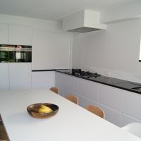 keuken in Arendonk modern laminaat wit granieten werkvlak met onderbouw spoeltafel en vlakbouw gasvuur
