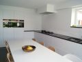 keuken in Arendonk modern laminaat wit granieten werkvlak met onderbouw spoeltafel en vlakbouw gasvuur